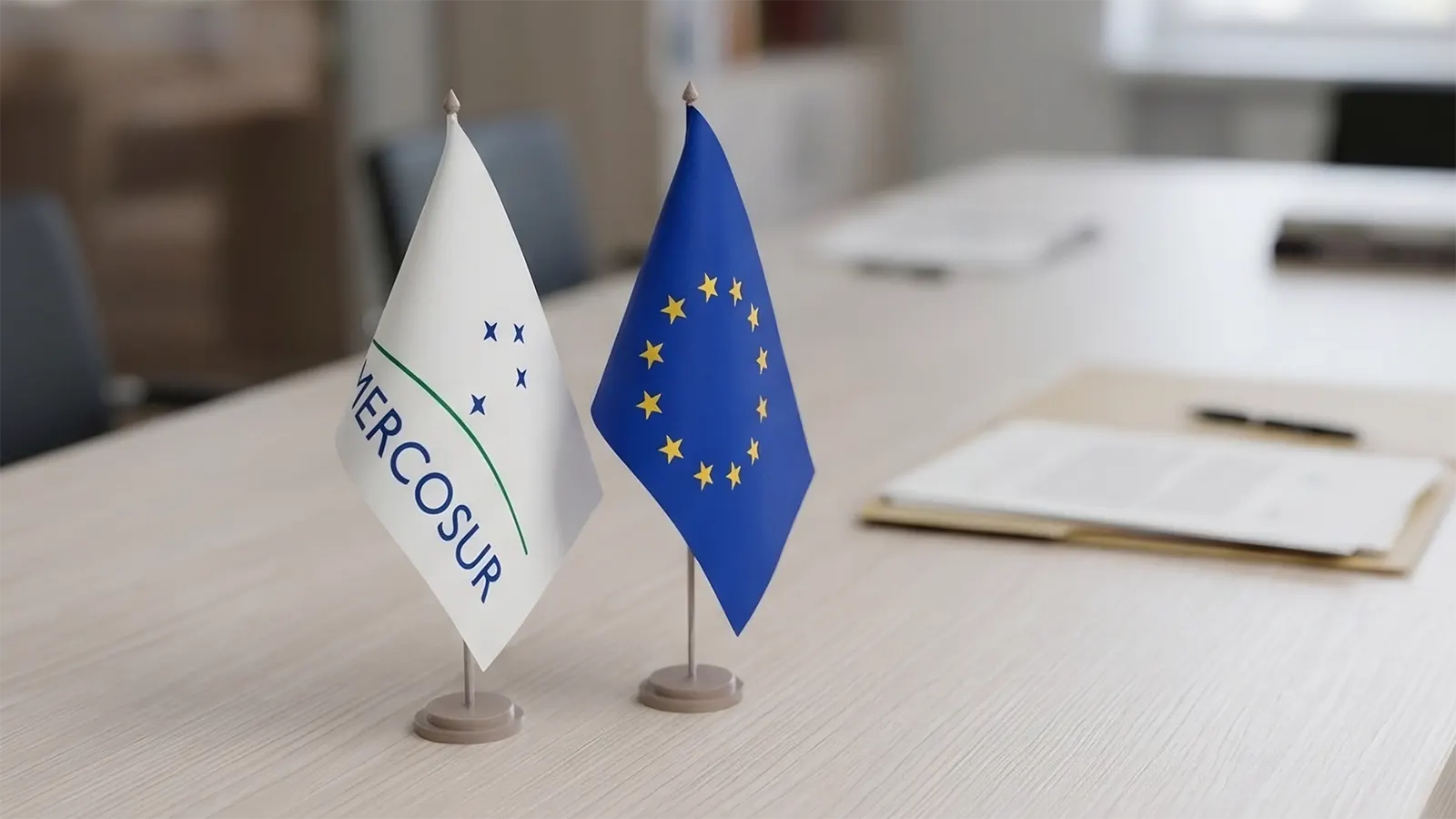 mini banderas del mercosur y la unión europea sobre un escritorio